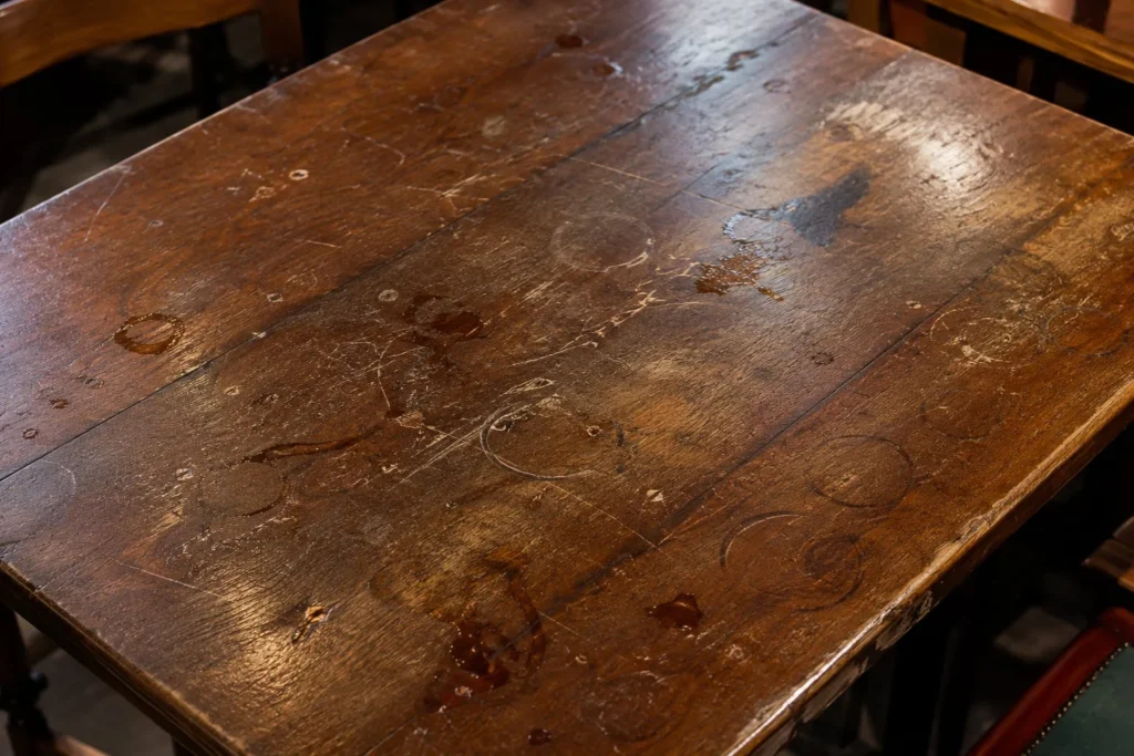 Mesa de madera con daños evitables con un muletón acolchado o transparente de Hulemarket